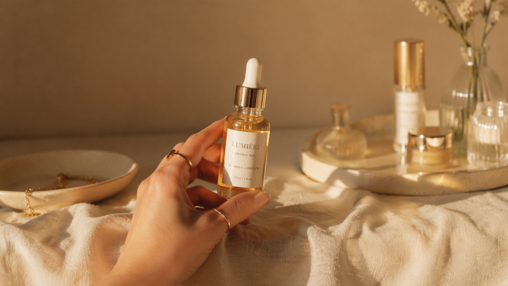 Woman's hand holding a glass serum dropper in warm window light, a simple skincare ritual for women in their 40s